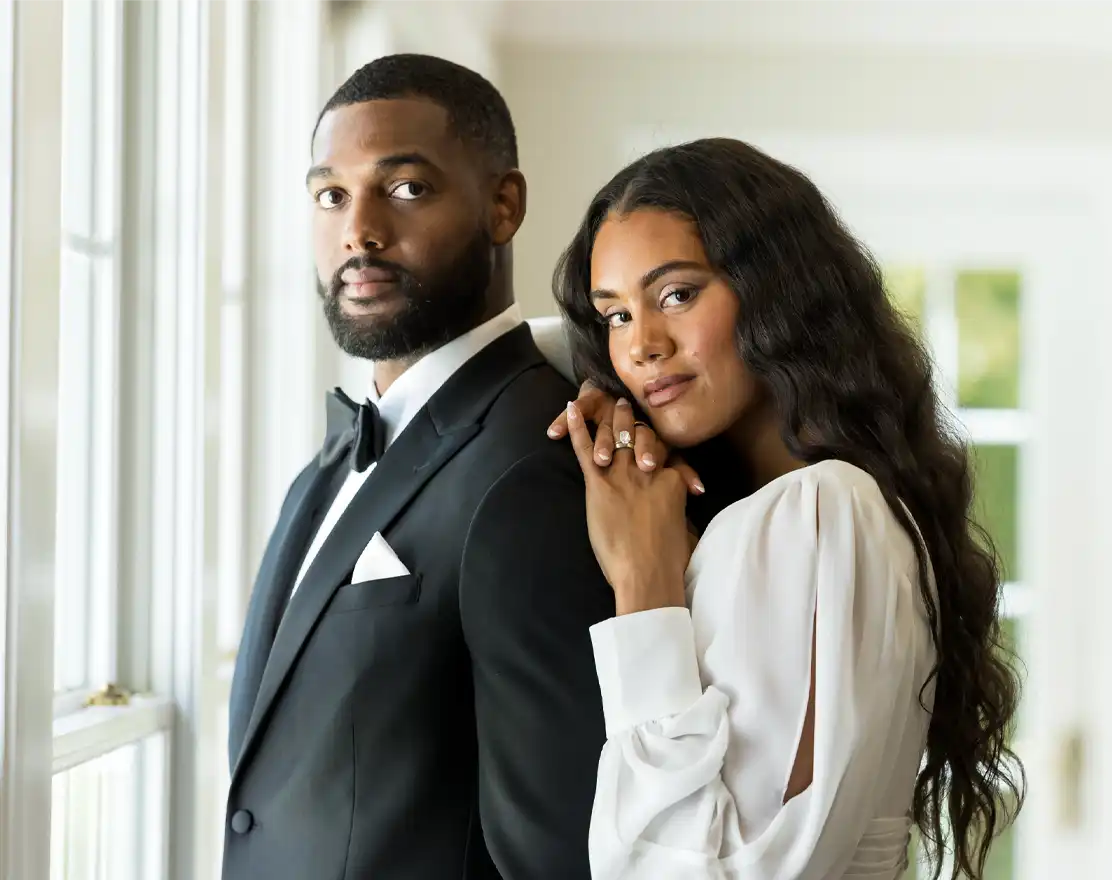 Groom in a black tuxedo with his bride in a white gown