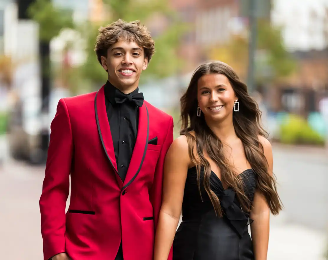 Prom couple, him in a red tuxedo jacket and her in a black dress